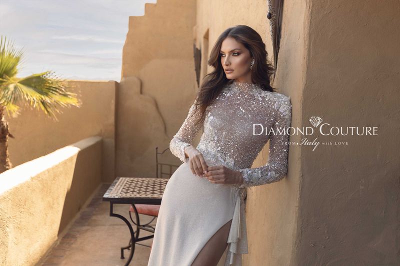 Abito da sposa Diamond Couture 2027: a mezza figura, corpetto ricamato a collo alto con maniche lunghe e spacco, sulla terrazza di un riad