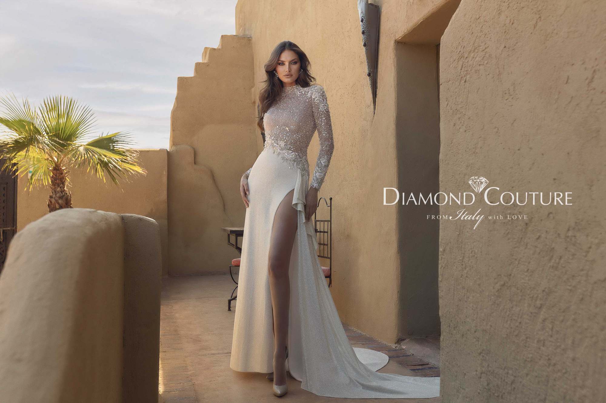 Abito da sposa Diamond Couture 2027: a figura intera, colonna glitterata con spacco alto e strascico, sulla terrazza di un riad