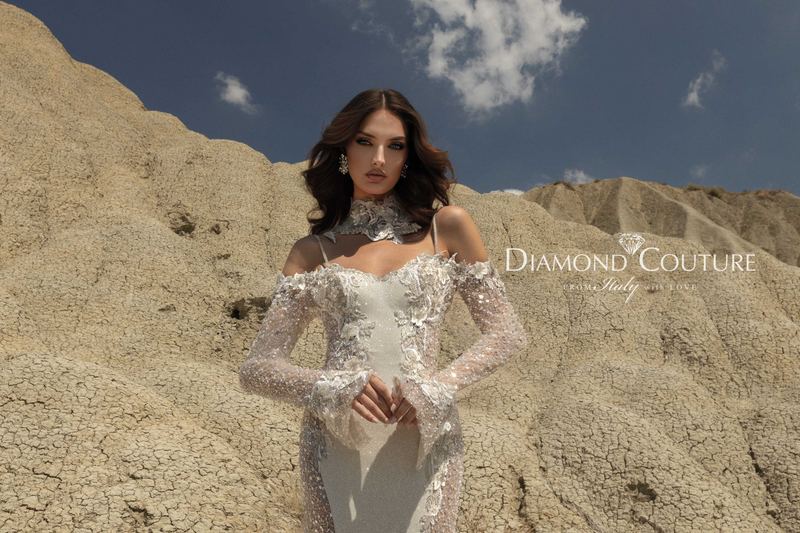Abito da sposa Diamond Couture 2027: spalle scoperte, maniche lunghe trasparenti e collarino in pizzo, tra i calanchi del deserto