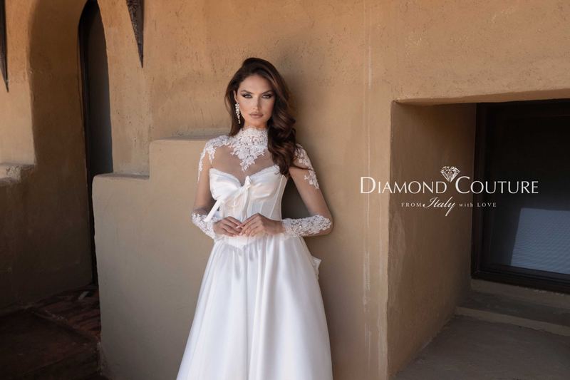 Abito da sposa Diamond Couture 2027: corpetto a cuore con fiocco, collo alto e maniche trasparenti con pizzo, gonna in mikado, in un riad