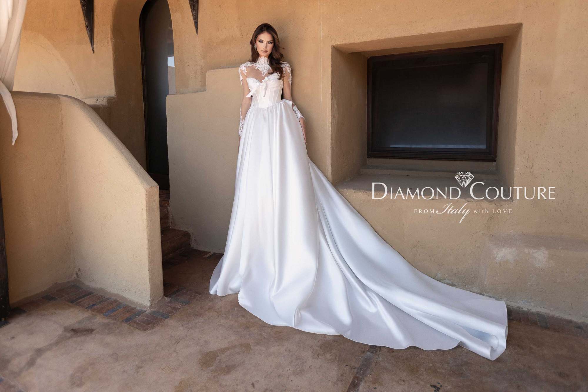 Abito da sposa Diamond Couture 2027: a figura intera, gonna ampia in mikado con lungo strascico e maniche in pizzo, nella corte di un riad