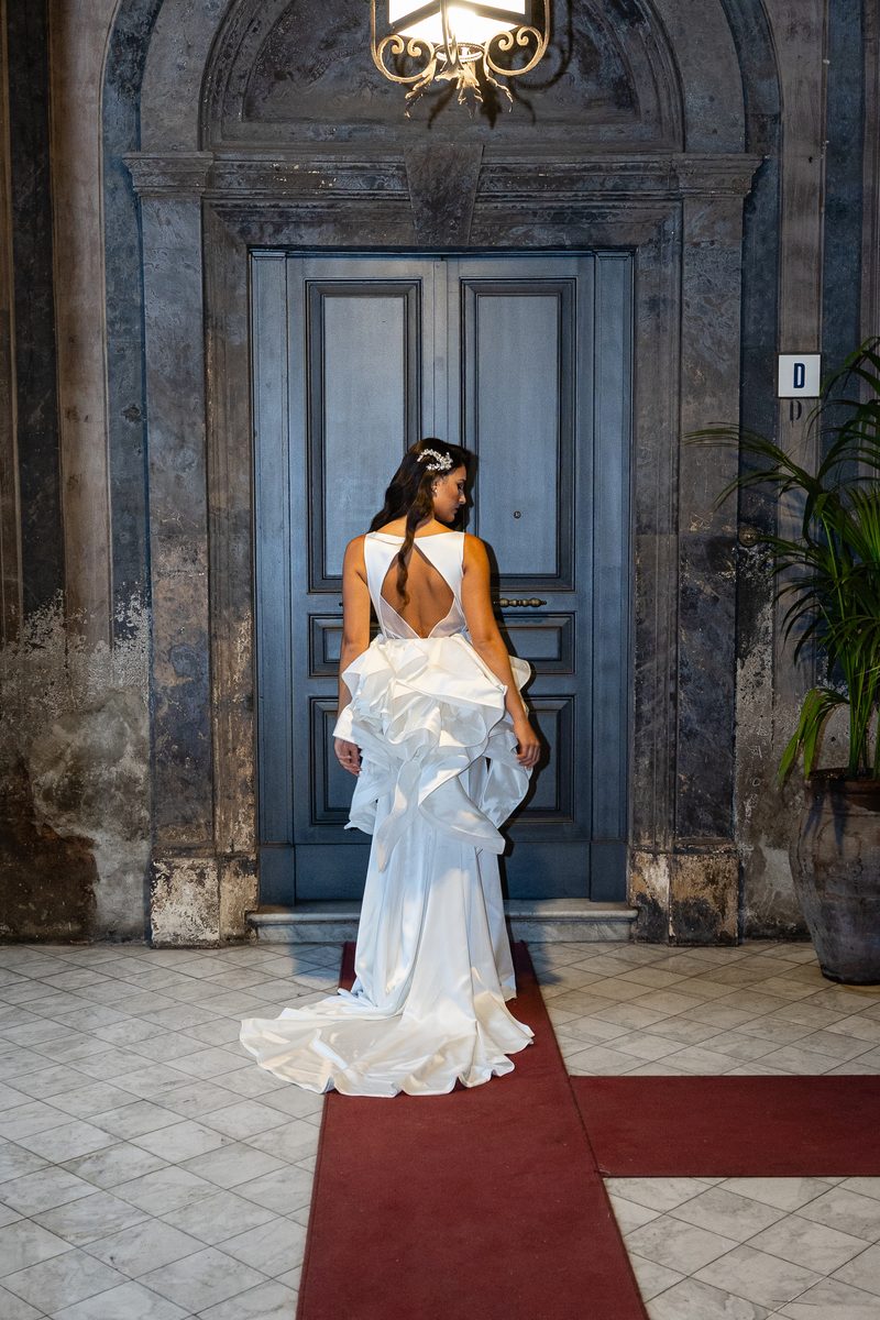Trunk Show Nagae Bridal: abito da sposa visto di spalle, con volumi a balze e strascico